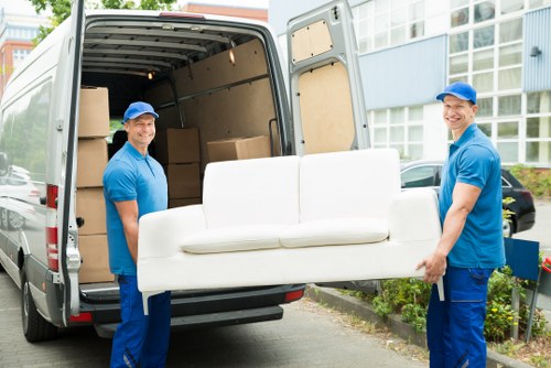 Furniture pick-up service removing a bulky sofa in Putney