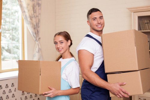 Removal team carrying furniture through a suburban home in Putney